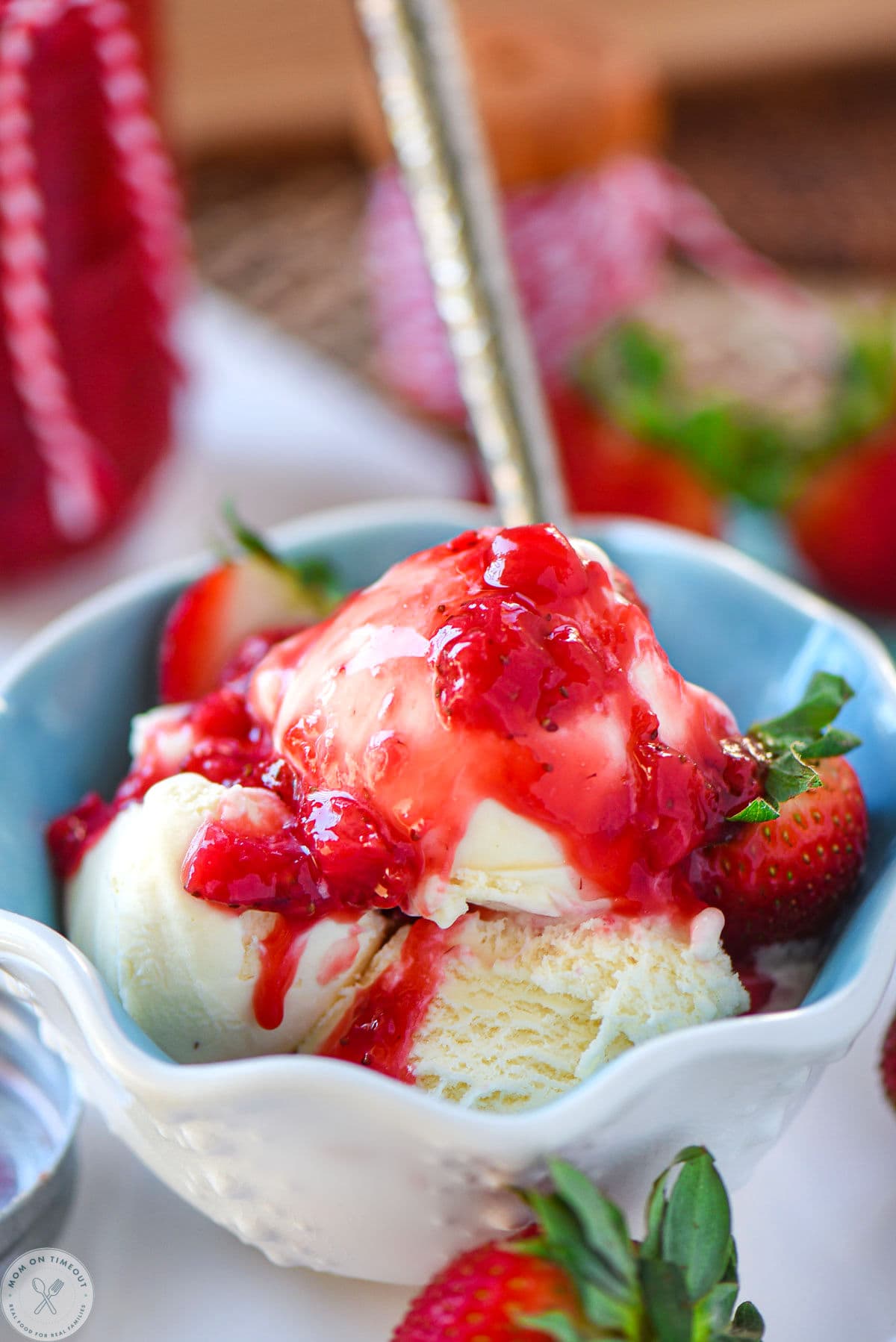 Vanilla ice cream in dessert bowl topped with homemade strawberry sauce.
