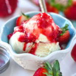 Vanilla ice cream in dessert bowl topped with homemade strawberry sauce.