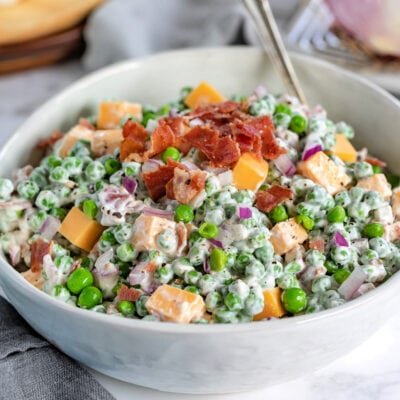 classic pea salad in a white bowl with spoon square