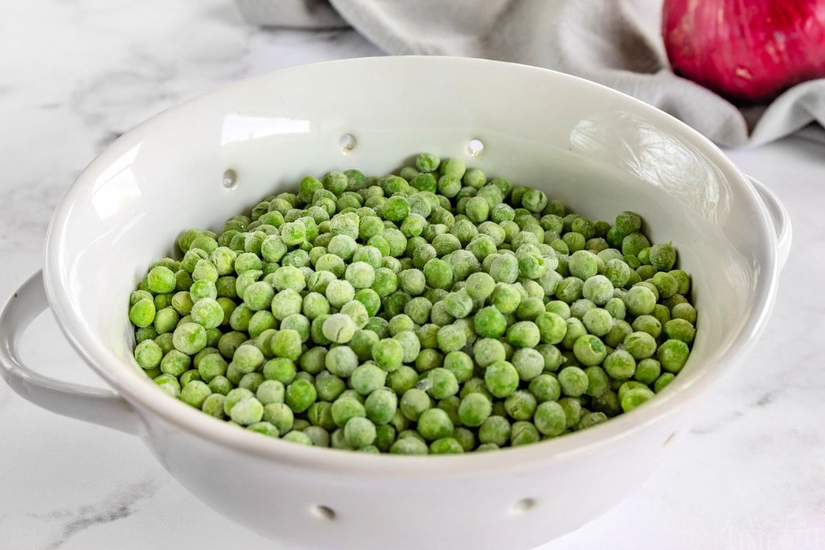 frozen peas in white colander