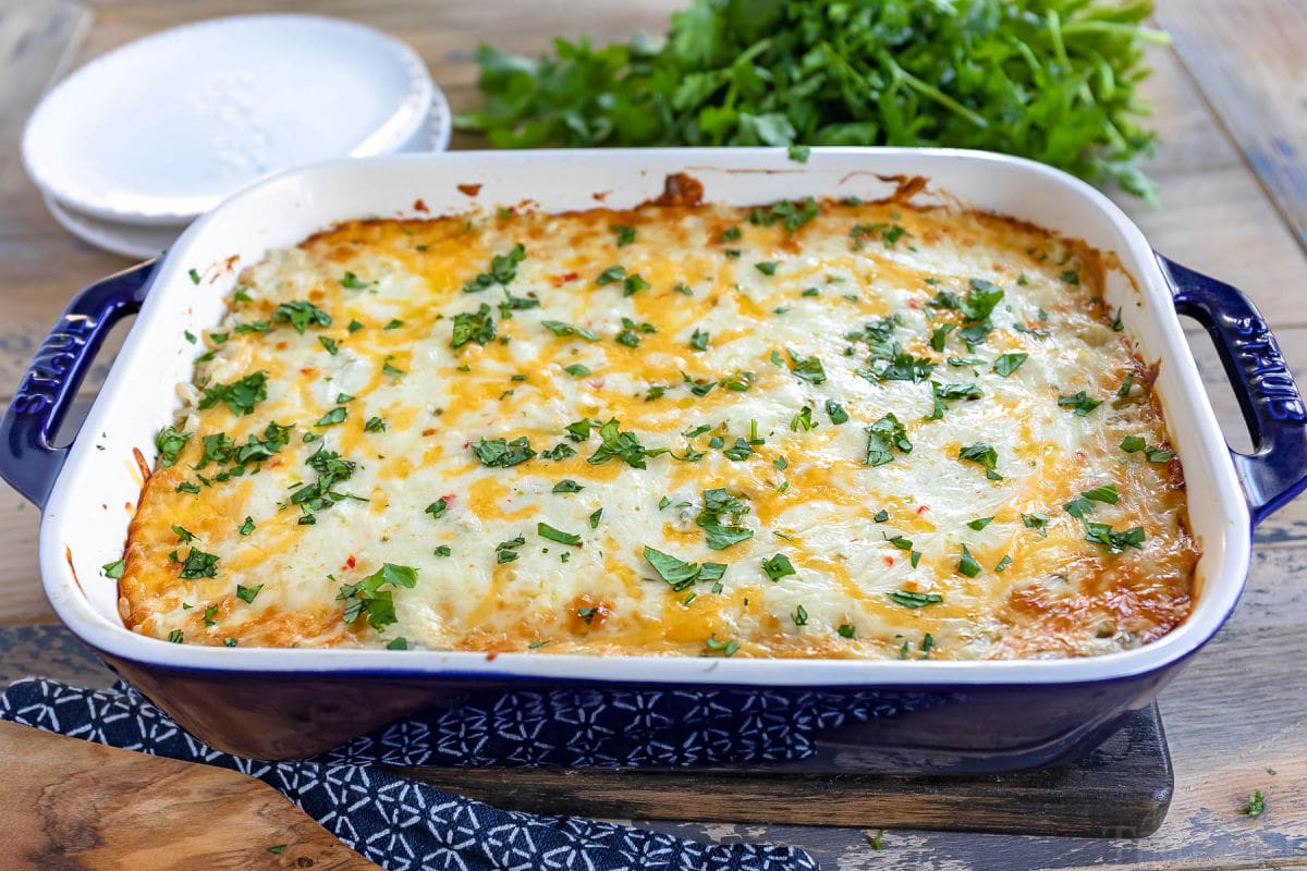 green chile rice in casserole dish sitting on wood board