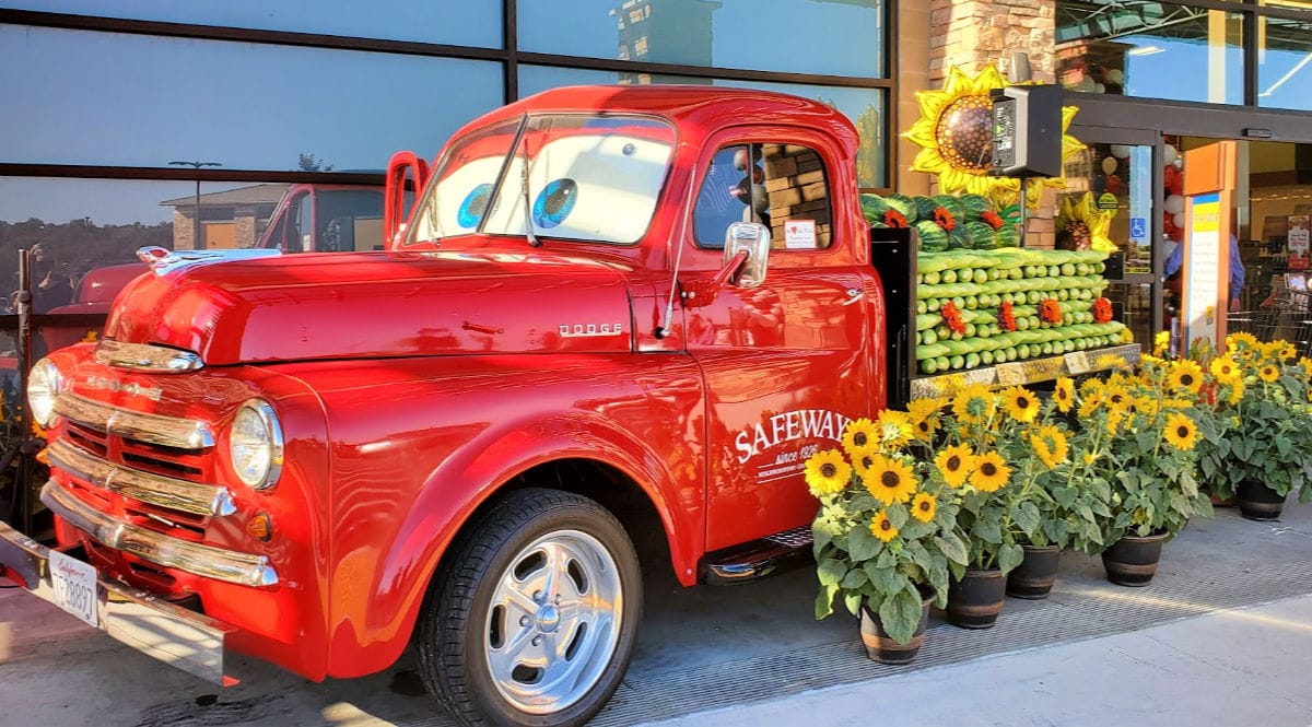 red safeway truck with produce on flatbed of truck in front of store