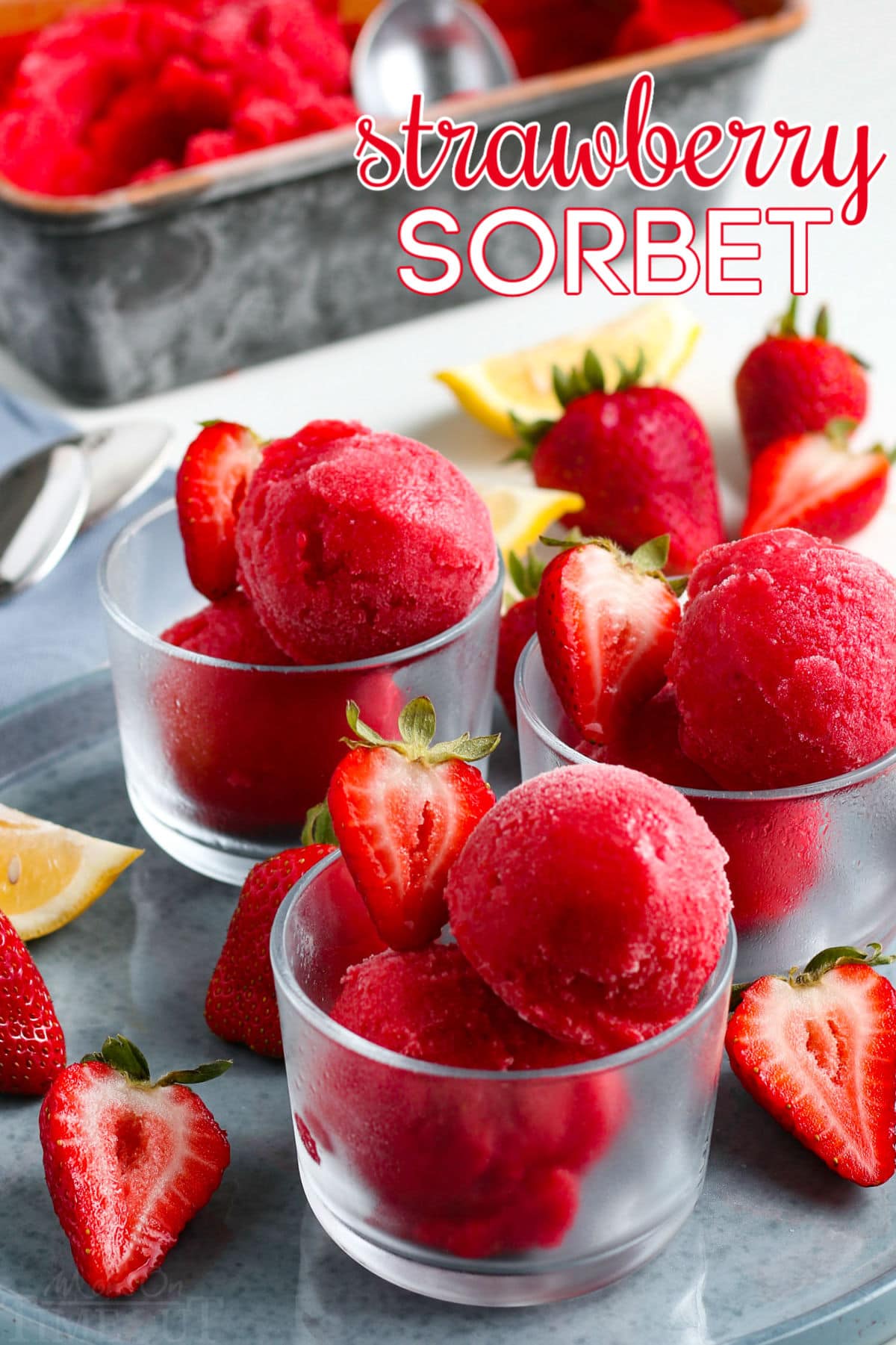 strawberry sorbet recipe on gray plate in glass jars with fresh strawberry slices and text overlay