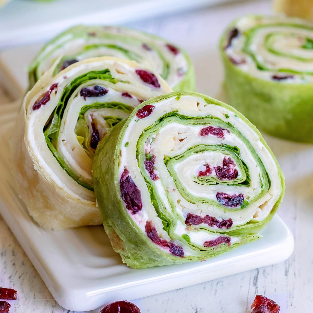 https://www.momontimeout.com/wp-content/uploads/2020/06/turkey-pinwheels-recipe-with-dried-cranberries-on-small-white-cutting-board-squared.jpg