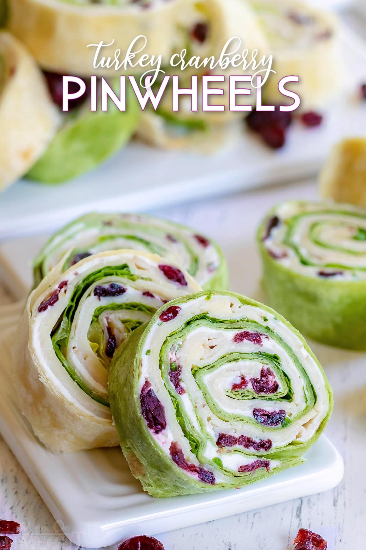 turkey pinwheels recipe with dried cranberries on small white cutting board