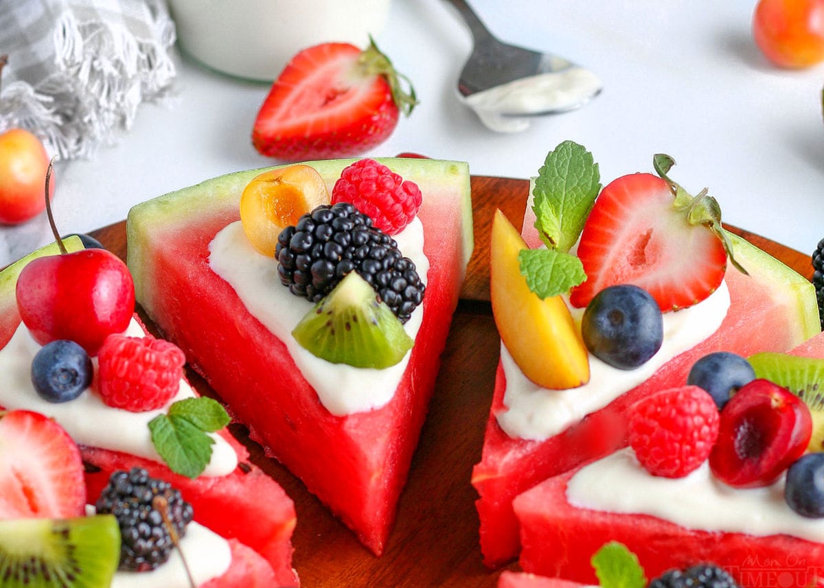 watermelon pizza recipe cut into wedges on wood cutting board