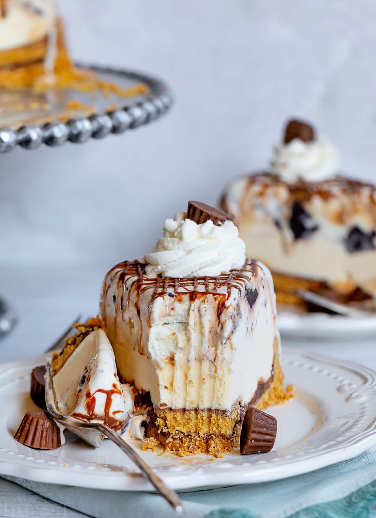 chocolate peanut butter ice cream cake slice on white plate with one bite removed