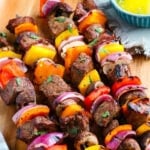 grilled steak kabobs ready to eat on wood plate square