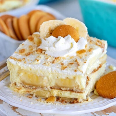 the best banana pudding recipe served on a white plate garnished with whipped cream and nilla wafers
