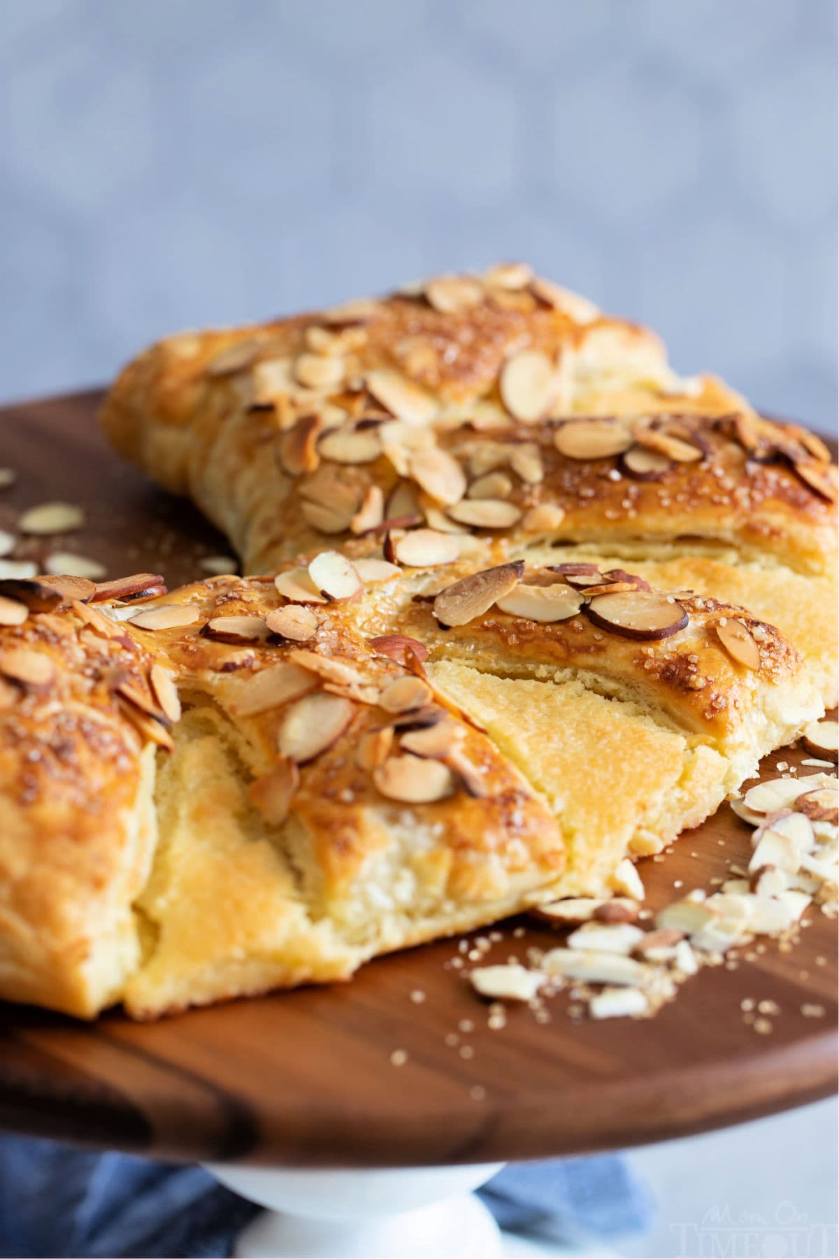 Almond Bear Claw recipe on white cake stand with wood top