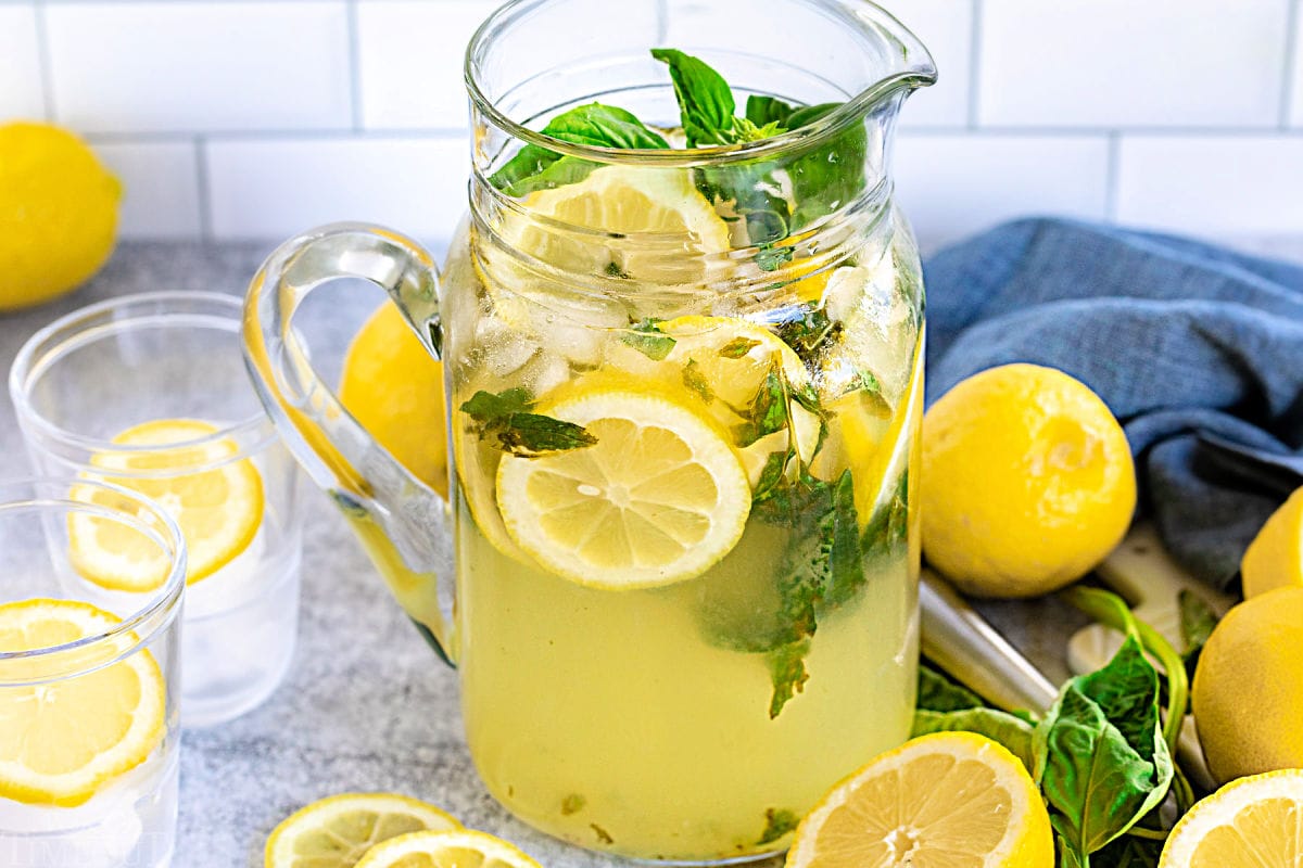 basil lemon drop prepared in pitcher with two empty glasses on the side