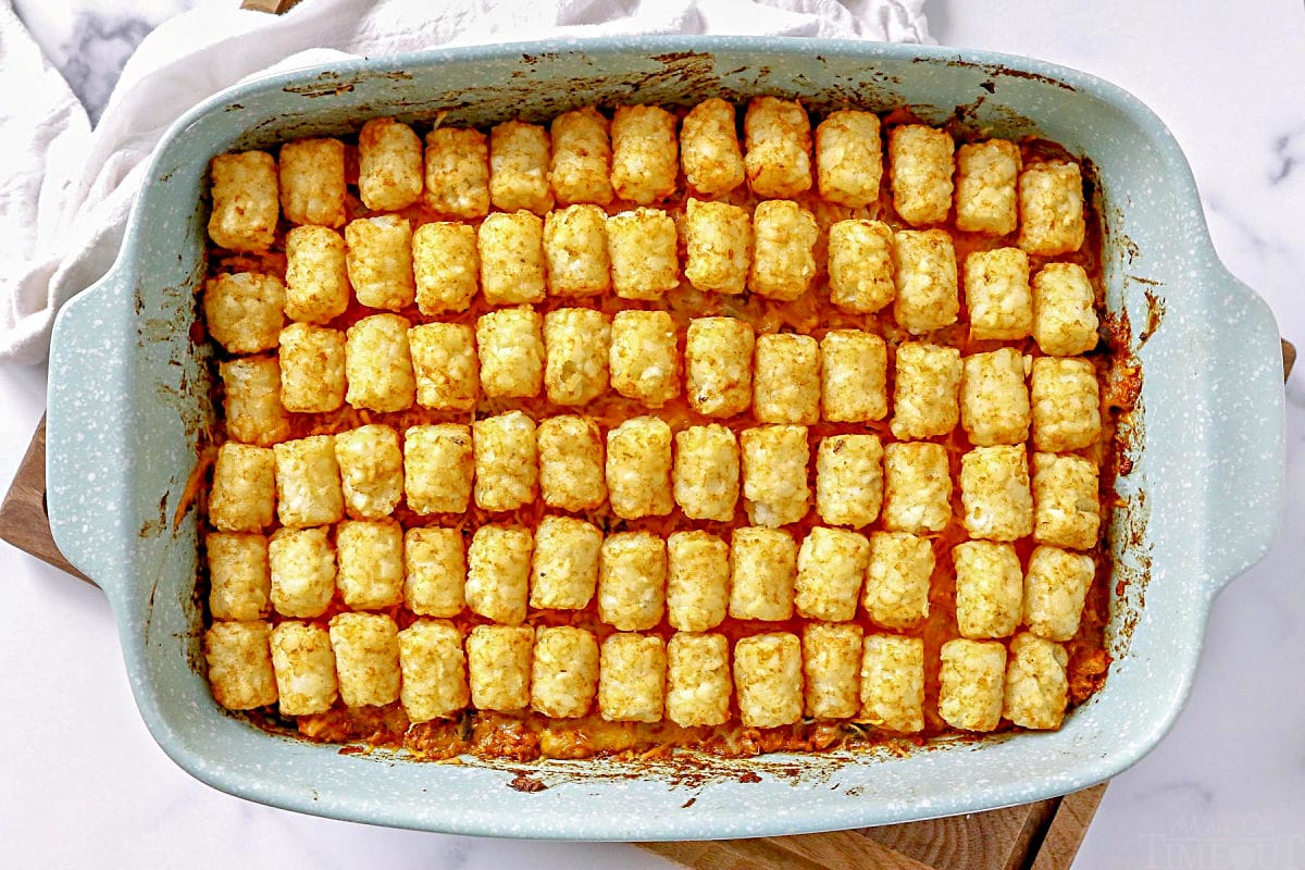 taco tater tot casserole cooked in casserole dish sitting on wood cutting board