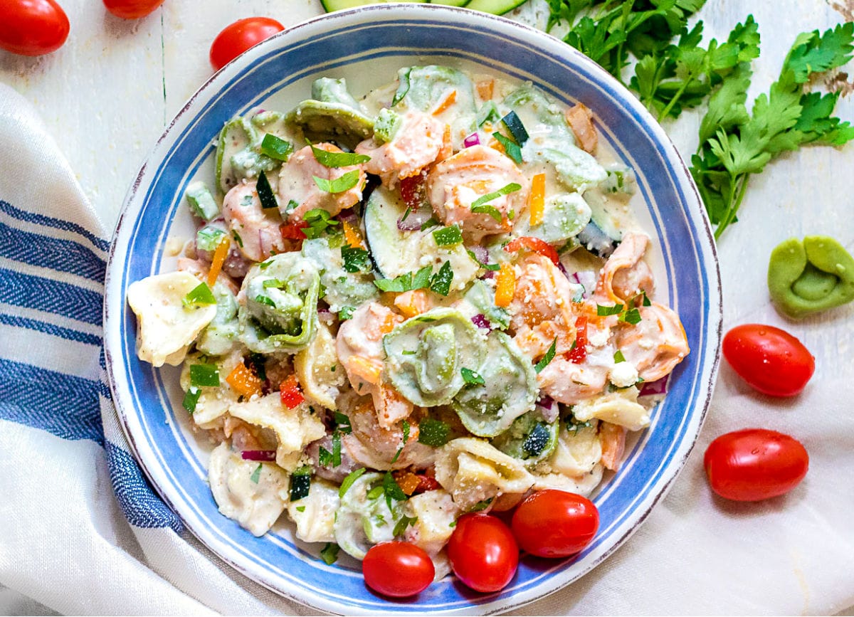 tortellini pasta salad with creamy dressing in white and blue bowl