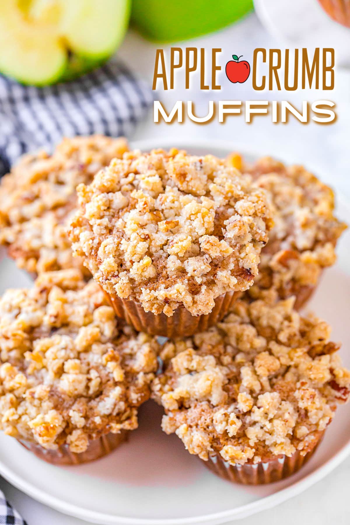 five apple crumb muffins on white plate with blue and white napkin beneath plate and text overlay at top