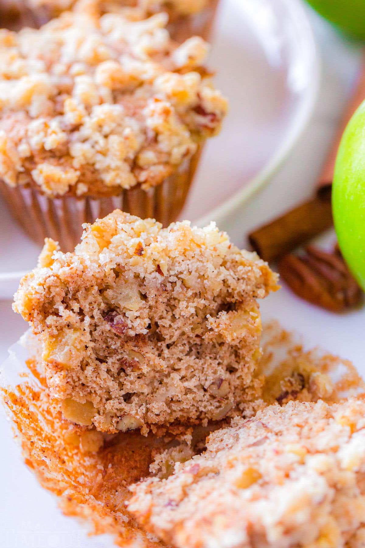 apple muffin split down the middle sitting on it's paper liner