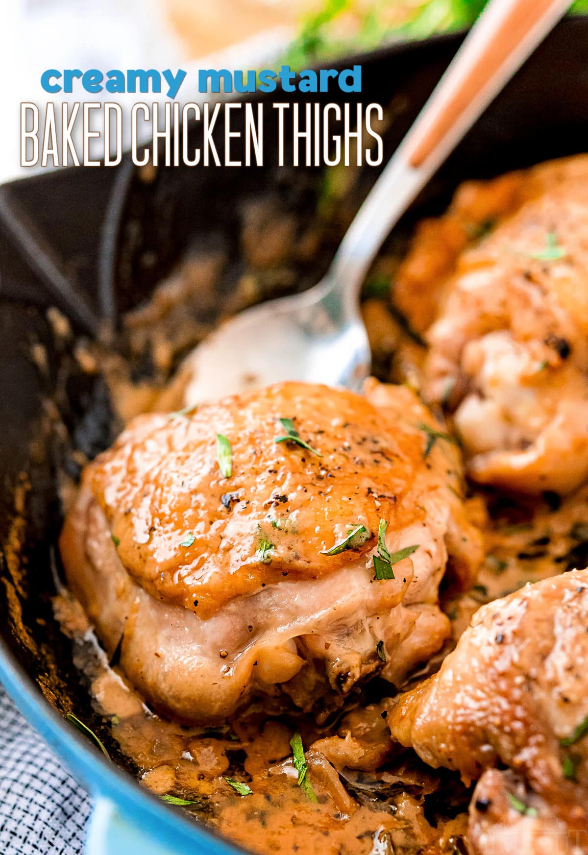 baked chicken thighs with mustard sauce in cast iron blue staub skillet with text overlay