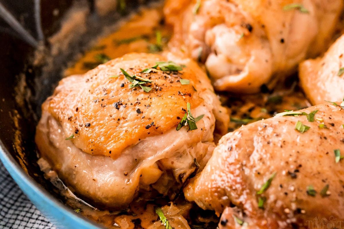 baked chicken thighs with mustard sauce on top in cast iron skillet