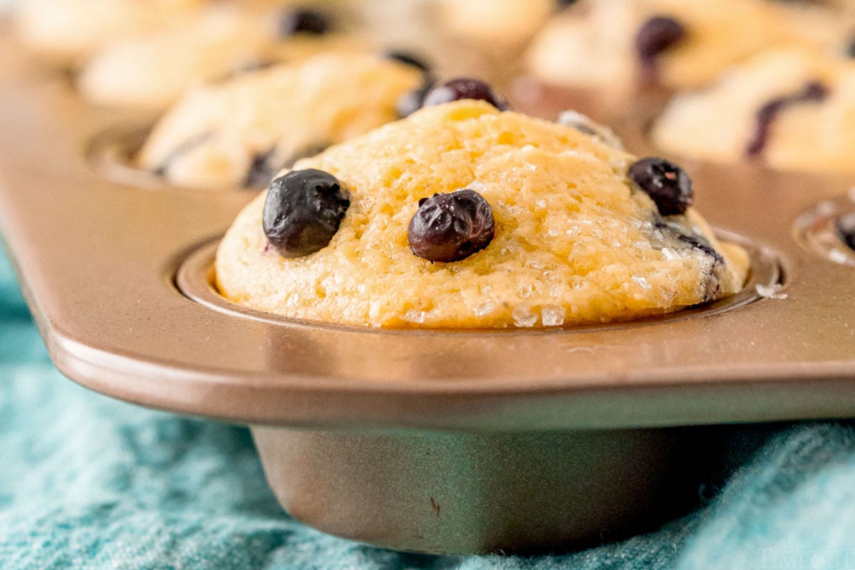 close up of corn muffin in muffin tin with blue napkin underneath the pan