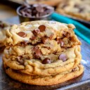 stack of chewy chocolate chip cookies on dark wood board square