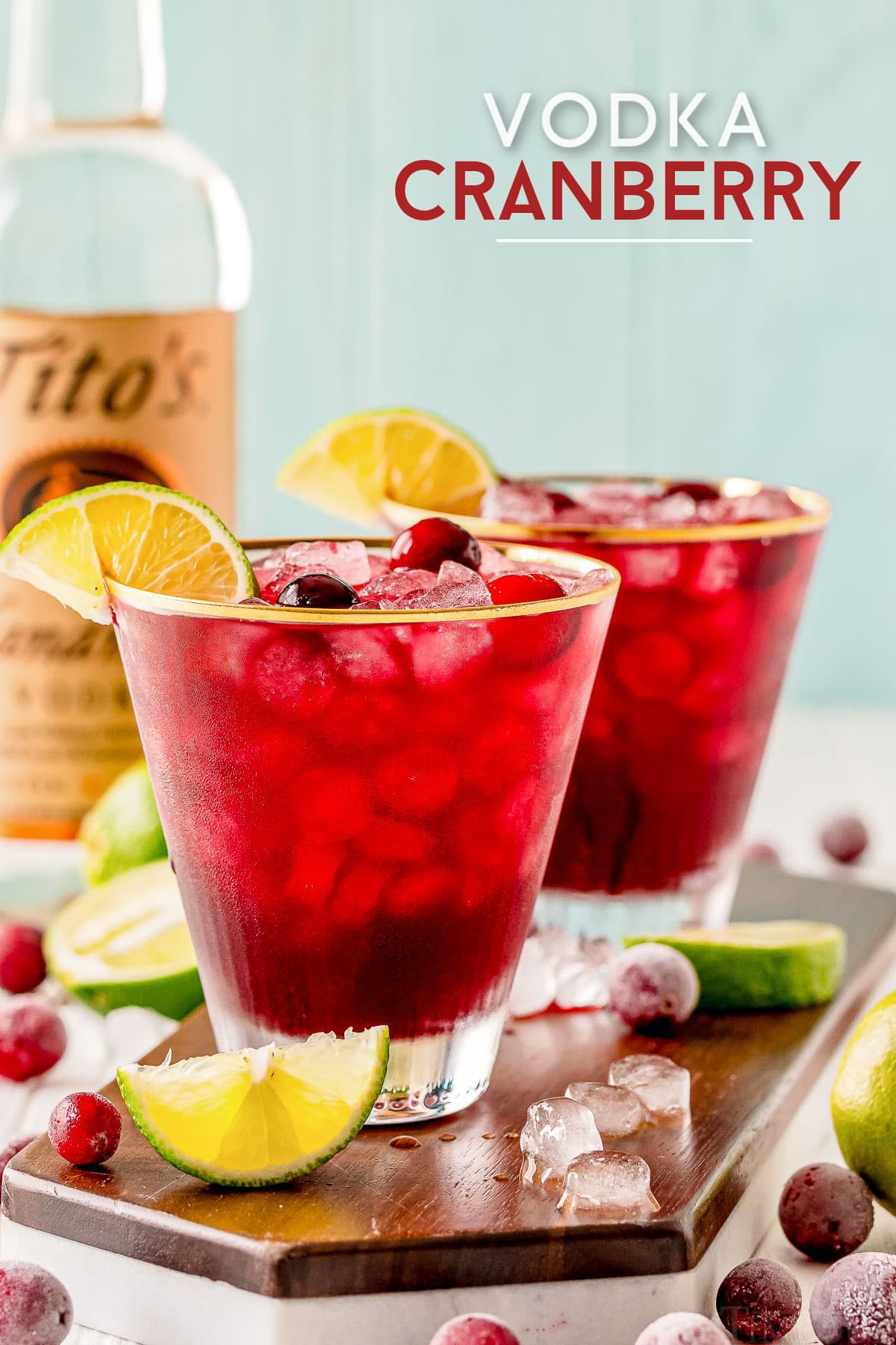 vodka cranberry recipe in two glasses with lime wedges and cranberries vodka bottle in background