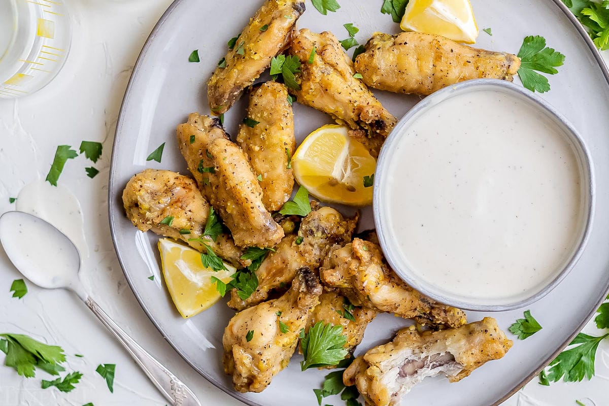 baked wings on plate with dipping sauce