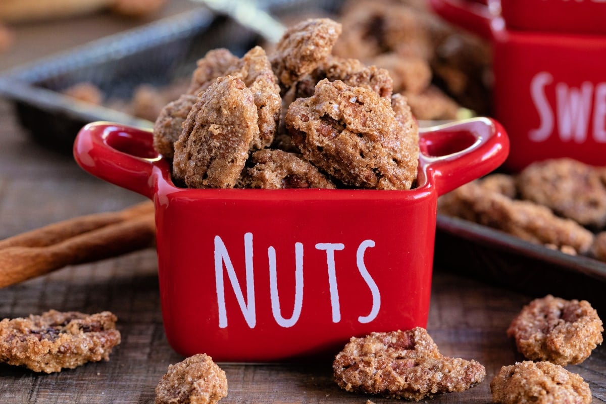 candied pecans in small red container with the word nuts printed on it