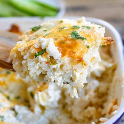 scoop of casserole on wood spoon with casserole dish in background square