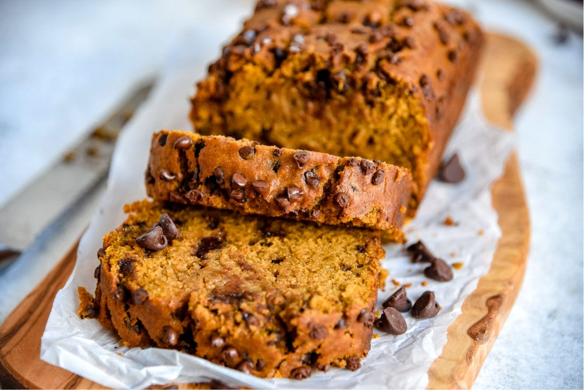 pumpkin bread loaf on cutting board with two slices cut off