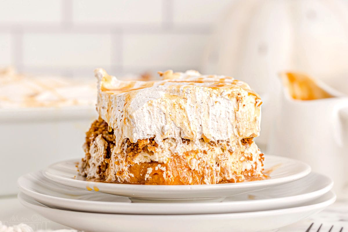 pumpkin dessert sitting on white plates with caramel sauce drizzled over the top