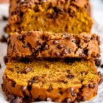 pumpkin bread loaf on cutting board with two slices cut off