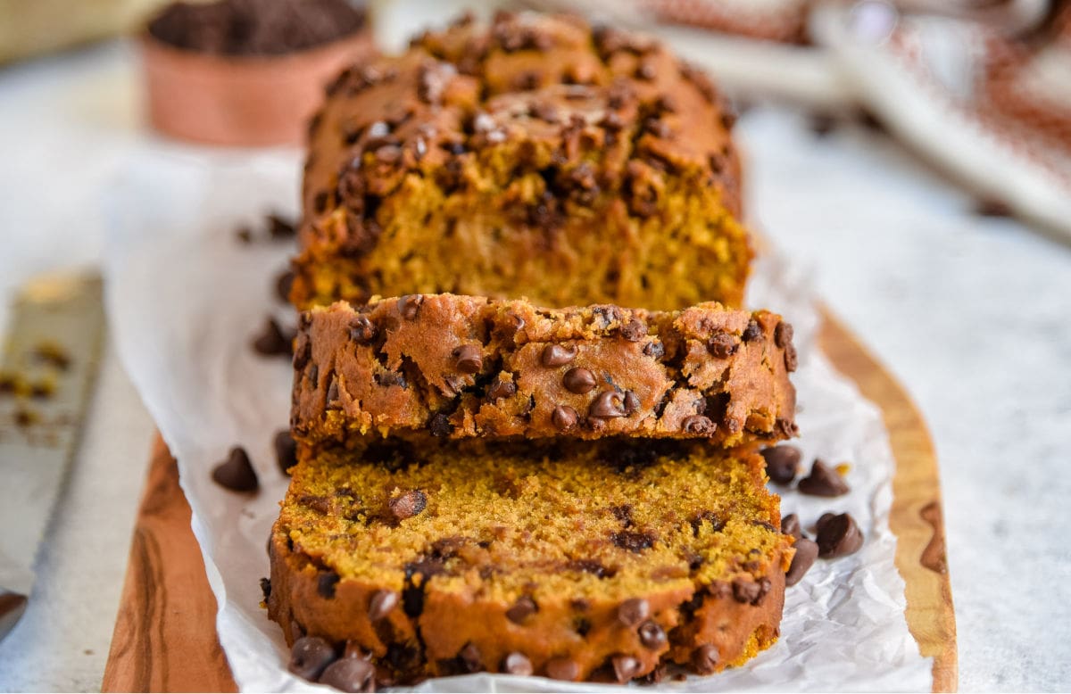 pumpkin bread loaf on cutting board with two slices cut off