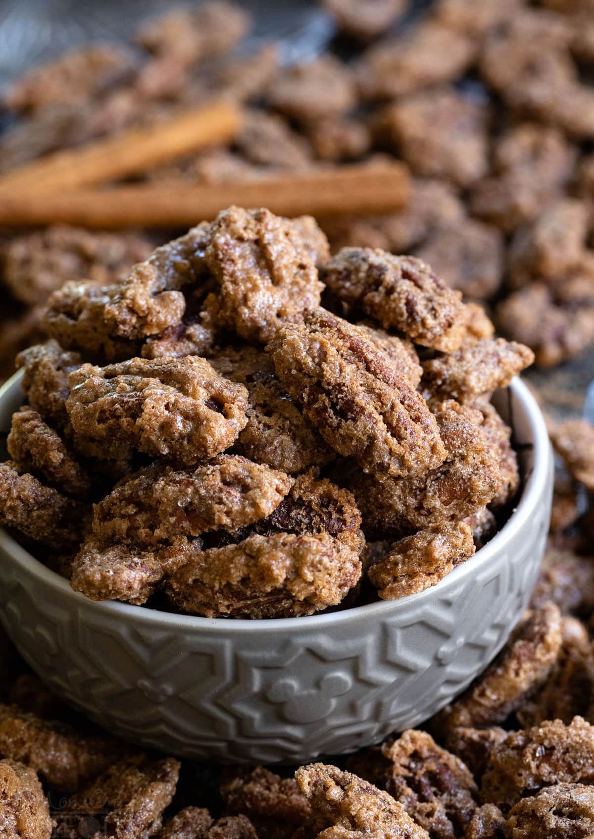 up close candied pecans with cinnamon sticks and pecans scattered about