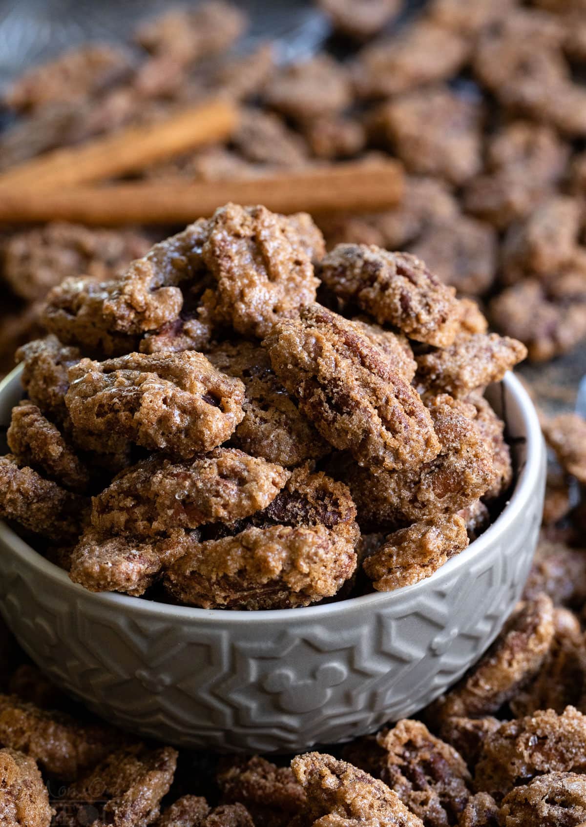 up close candied pecans with cinnamon sticks and pecans scattered about