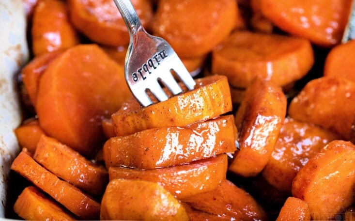 candied yams in baking dish with fork in it