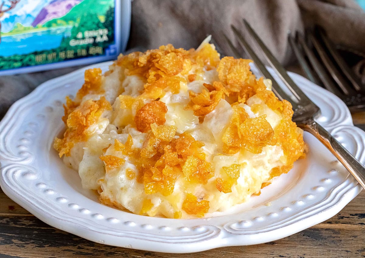 cheesy potatoes on white plate with challenge butter box behind it