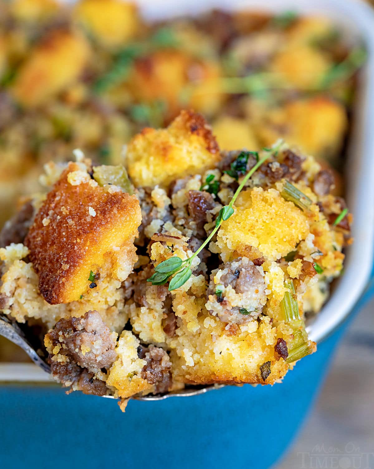 spoonful of cornbread stuffing with casserole dish in background