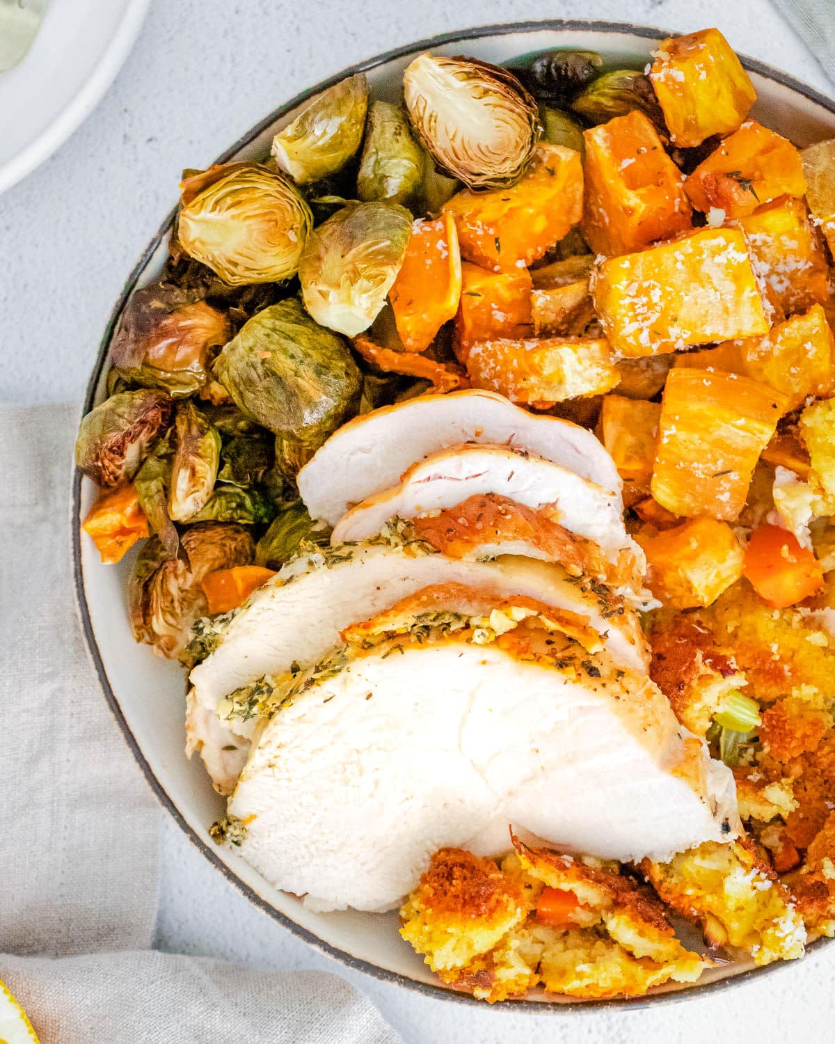 thanksgiving dinner on a plate with turkey cornbread stuffing Brussels sprouts and sweet potatoes