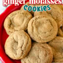 Chewy ginger molasses cookies piled high on a red plate.