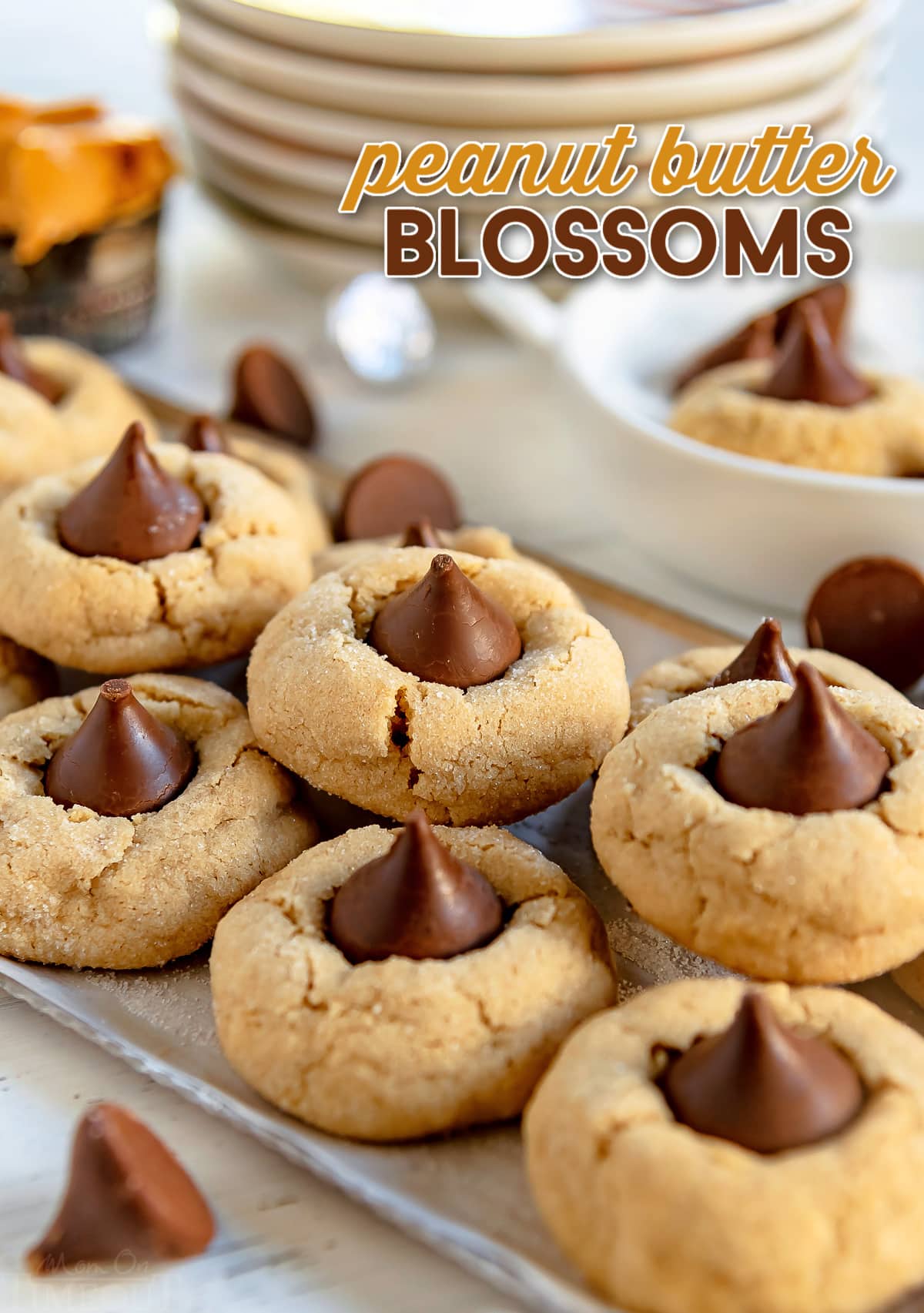 peanut butter blossoms stacked on metal serving tray with title overlay at top of image