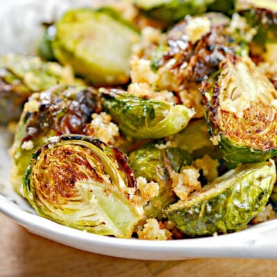 air fryer brussel sprouts in white bowl seasoned with garlic and Parmesan