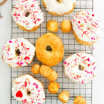 donuts cooling on wire rack some are already glazed and decorated