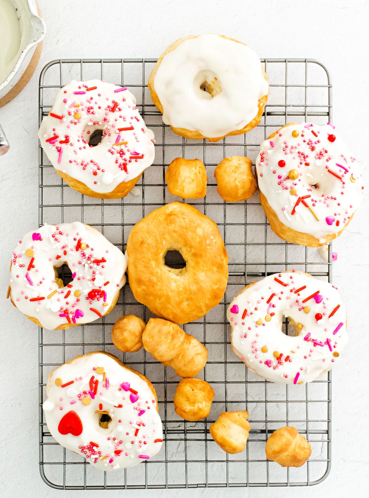 donuts cooling on wire rack some are already glazed and decorated