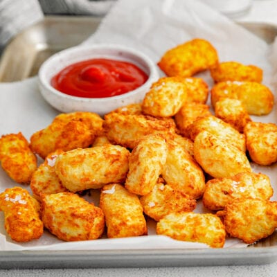 tater tots ready to be eaten with ketchup.
