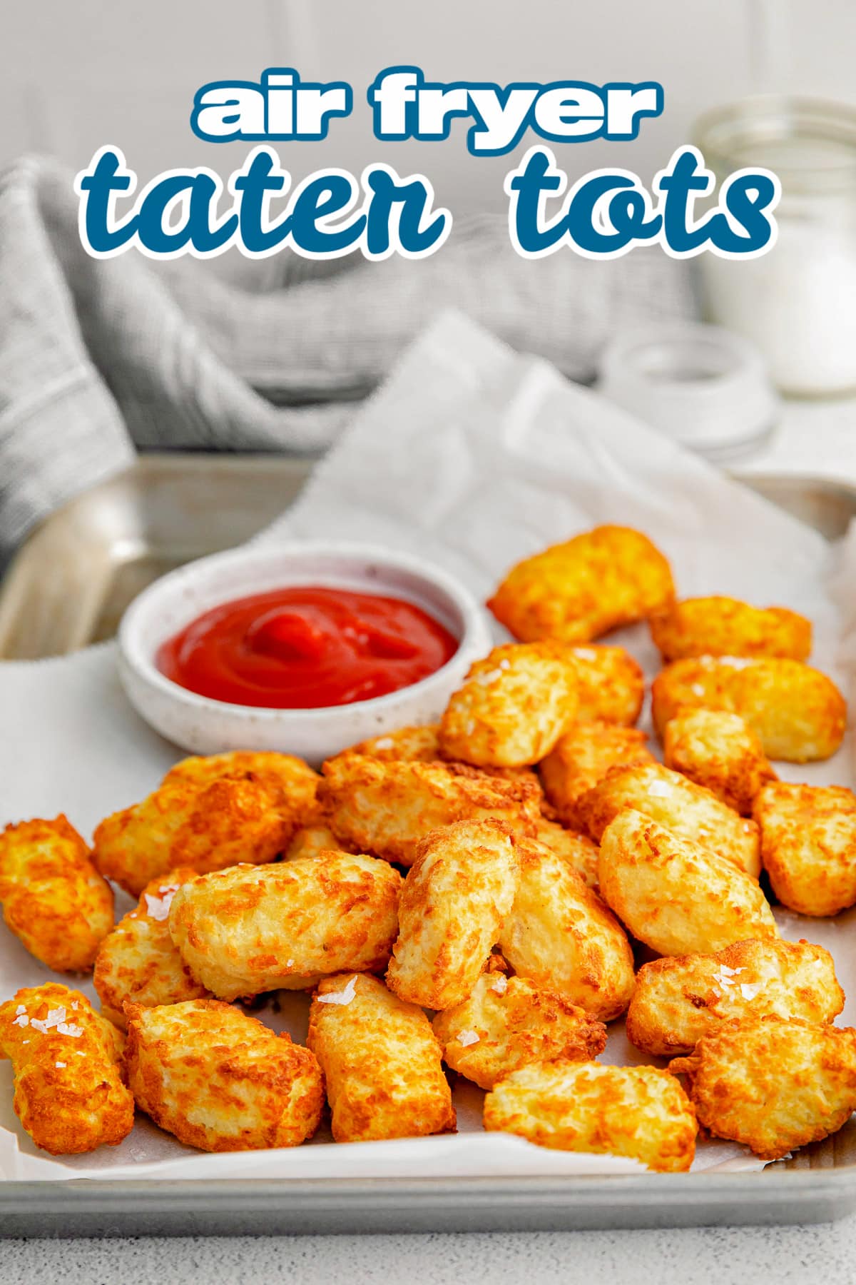 tater tots on sheet pan with small bowl of ketchup and title overlay at top of image.