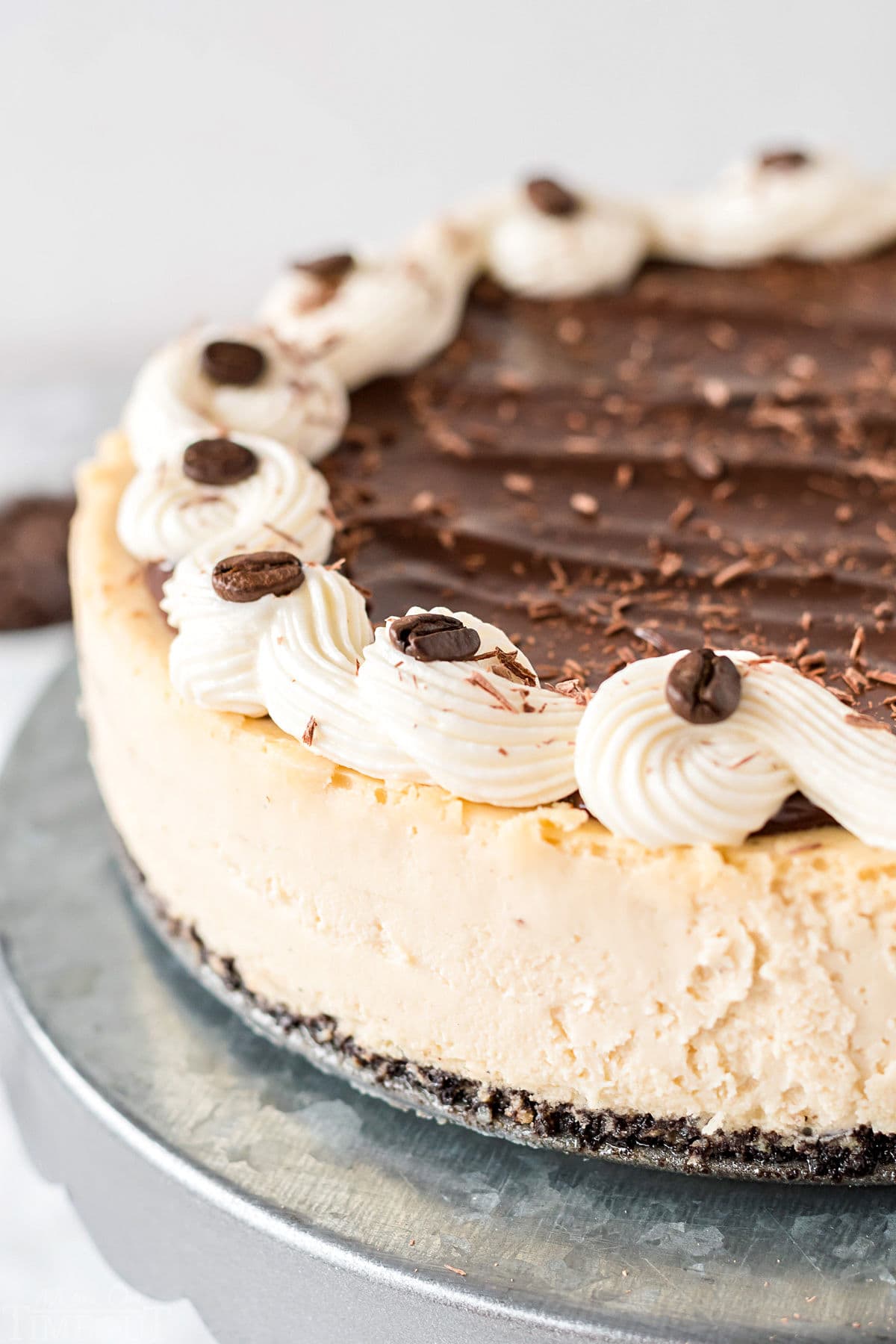 espresso cheesecake topped with cream cheese frosting chocolate ganache and espresso beans