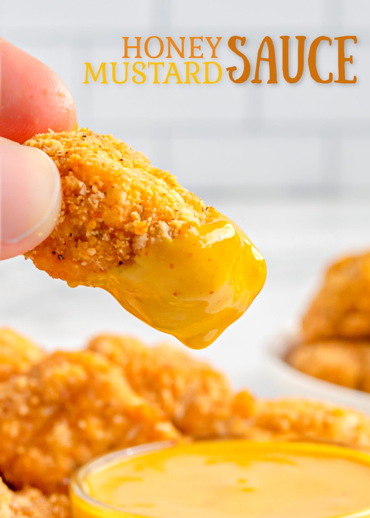 chicken nugget being dipped in honey mustard.