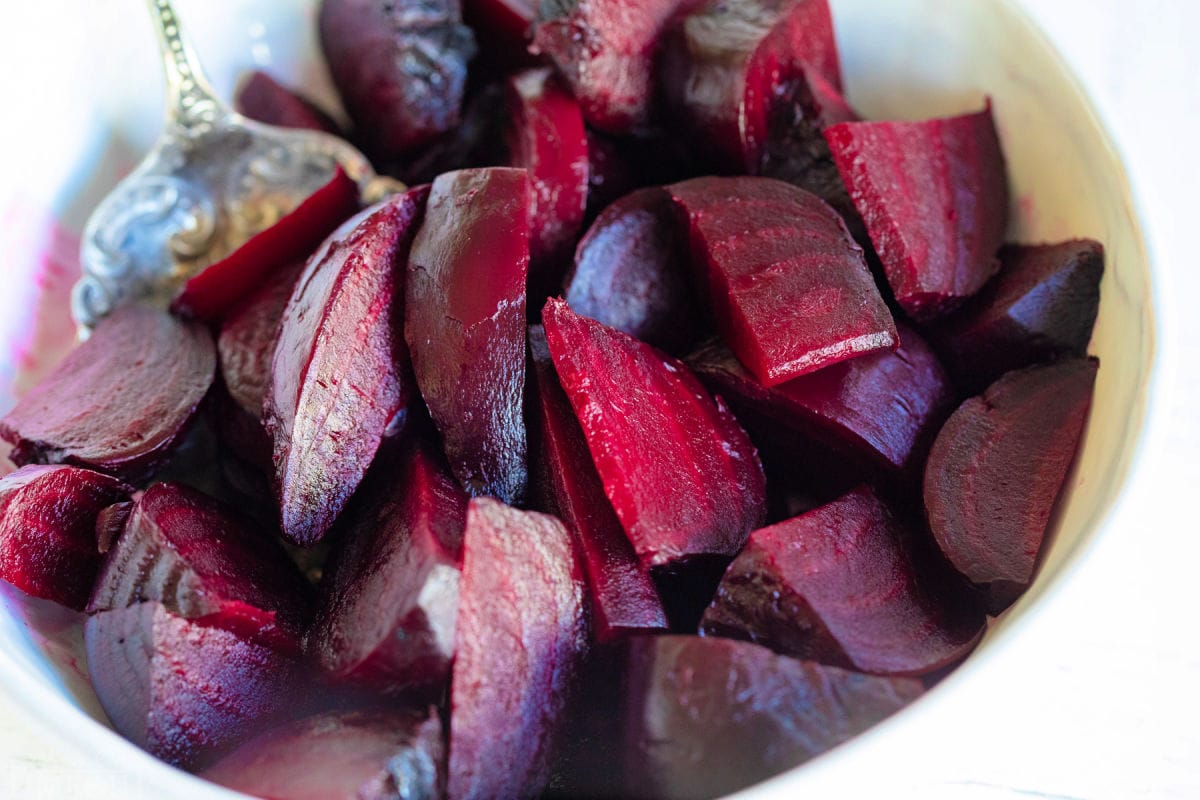 beets that have been roasted and cut into small pieces in a large white bowl.