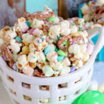 easter snack mix in white basket with pretzels, marshmallows and popcorn.