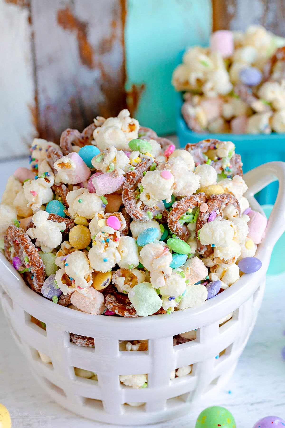 bunny bait snack mix with popcorn and pretzels in a white ceramic basket.