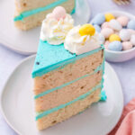 a slice of easter cake with bright blue frosting decorated with cadbury eggs.
